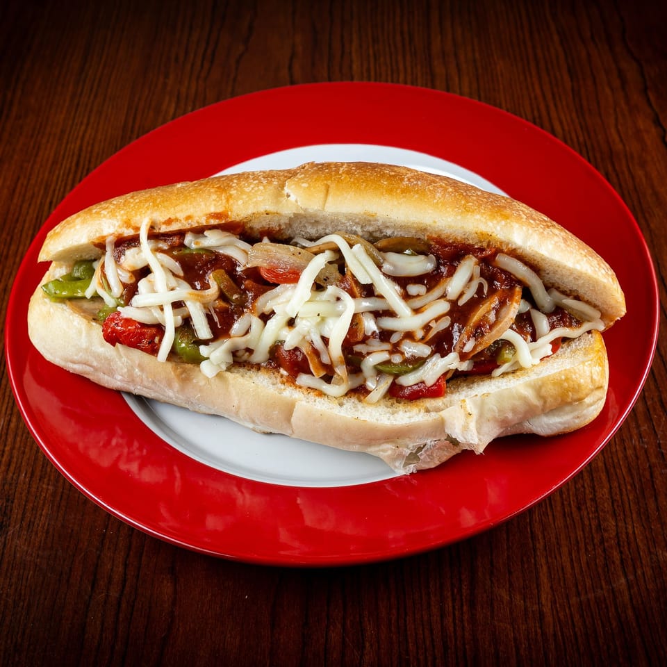 A GoGo Pizza sub sandwich with melted cheese, sauce, and vegetables on a red and white plate.